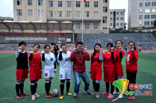 武汉科技大学研支团成员程梁和学生一起踢球练习。程梁 供图